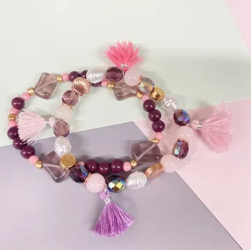 Colorful beaded bracelets with tassels on paper.