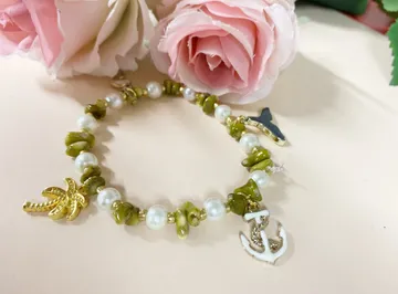 Armband mit rosa Rosen im Hintergrund.