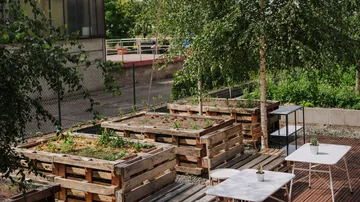 Wooden planters and tables on a patio.
