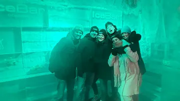 Group posing in an ice bar environment.