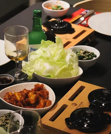 Korean meal setup with lettuce and sides.