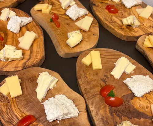 Cheese selections on wooden boards, garnished with tomatoes.