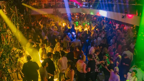 Voller Nachtclub mit bunten Lichteffekten.