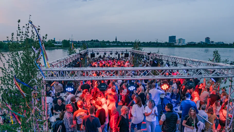 Crowd dancing on a boat at sunset.