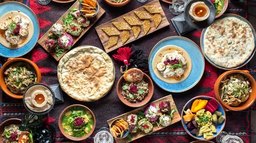 Assorted Middle Eastern dishes on colorful tablecloth.