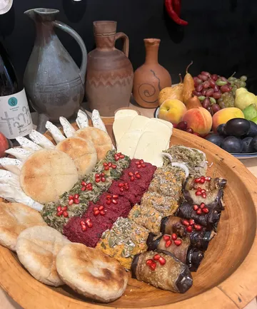 Platte mit verschiedenen Speisen und Krügen im Hintergrund.