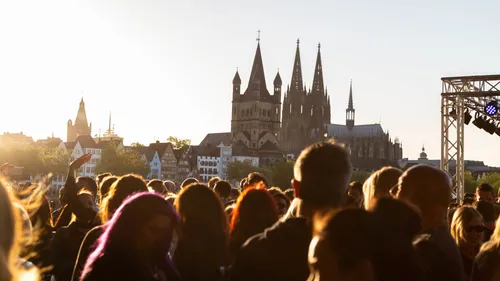 Crowd in front of Cologne Cathedral at sunset.