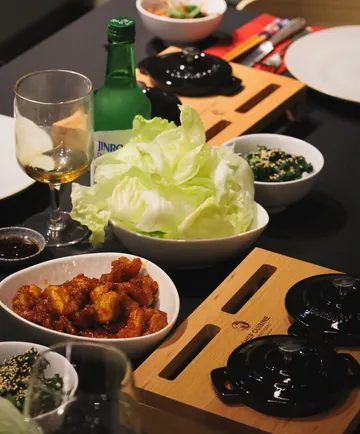 Koreanisches Essen auf Tisch mit Soju-Flasche.