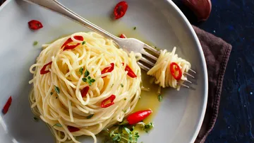 Spaghetti mit Chili und Kräutern auf Teller.