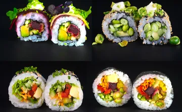 Vier bunte Sushi-Rollen auf schwarzem Hintergrund.