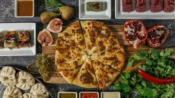 Käsekuchen umgeben von verschiedenen Gerichten und Früchten.