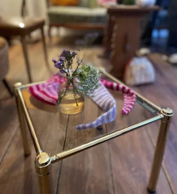 Vase mit Blumen auf Glastisch drinnen.