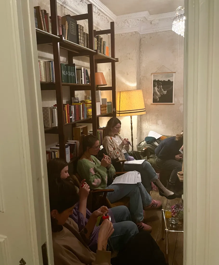 People knitting in a cozy living room.