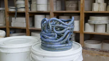 Blaue Keramikskulptur auf Behälter im Studio.