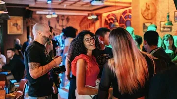 Menschen unterhalten sich in lebhafter Bar.