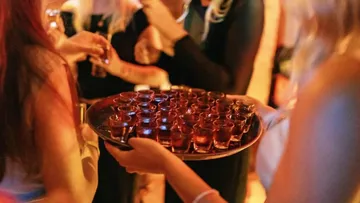 Tablett mit Shots auf einer lebhaften Party.