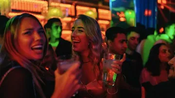 Menschen genießen Getränke in einem lebhaften Nachtclub.