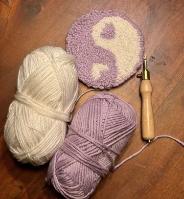 Yarn and crochet tool with a yin-yang design.