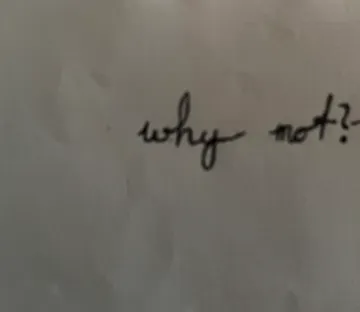 Kursive Schrift sagt 'why not?' auf Papier.