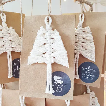 Weißer Makramee-Baum hängt an braunem Papier mit Zahlen.