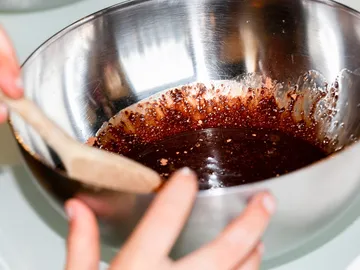 A bowl is stirred; dark dough is prepared.