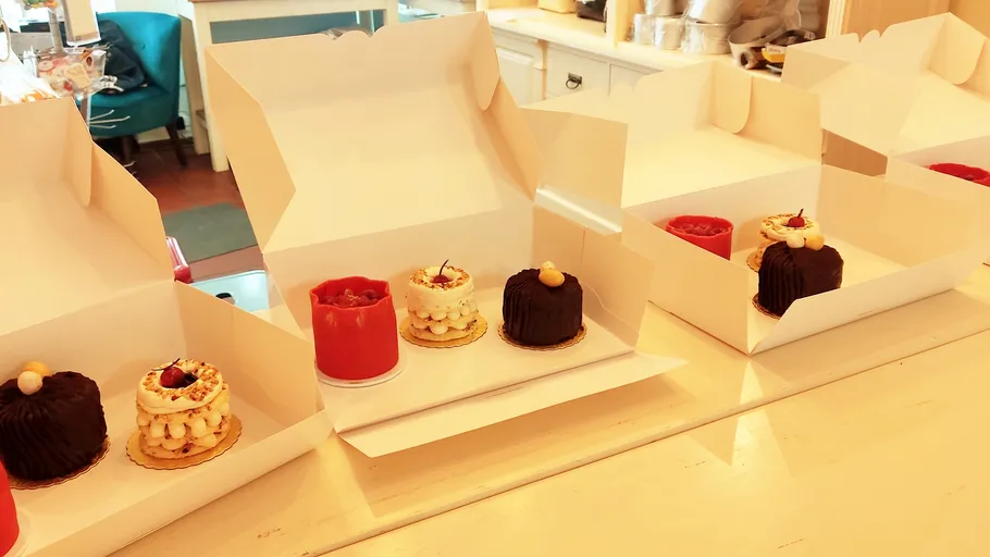 Cakes in open boxes on counter.