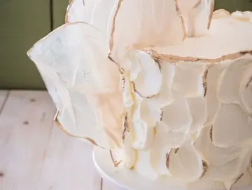 Eine mehrschichtige Torte mit dekorativer Frosting-Dekoration.