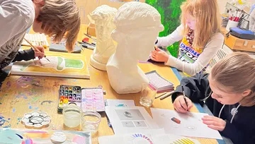 Children drawing and painting in an art class.
