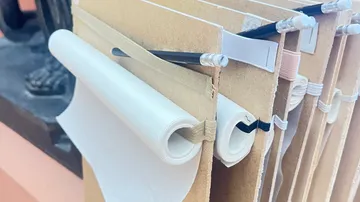 Hängemappen mit befestigten Papierrollen.