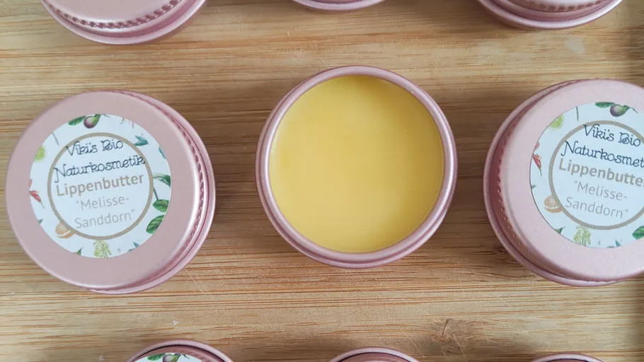 Lippenbalsam in Dosen auf Holzoberfläche.