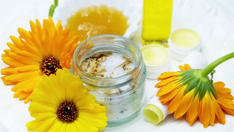 Ringelblumen mit Hautpflegeprodukten auf Tisch.