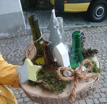 Dekorative Flaschen auf Holzsockel im Freien.