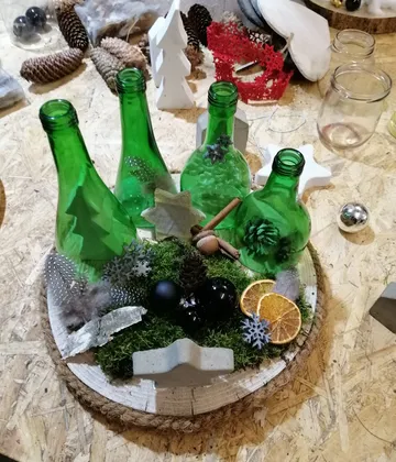 Green bottles and decorations on wooden base.