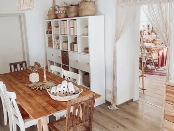 Wooden table with chairs, decorated, in a bright room.