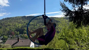 Person im Luftring vor landschaftlicher Waldkulisse.