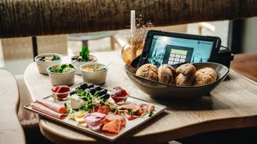 Frühstücksauswahl auf Tisch mit Tablet.