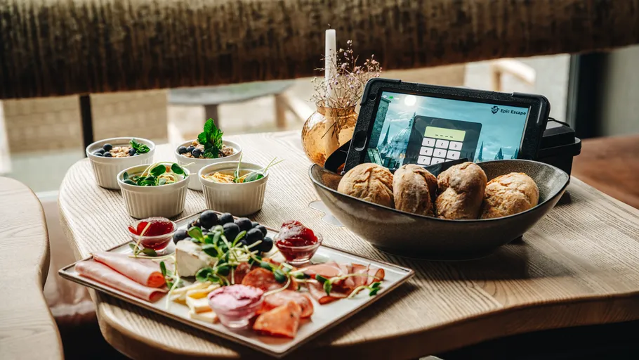 Frühstücksplatte mit Brot und Tablet auf Tisch.