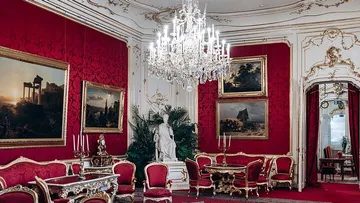 Opulent room with chandelier and red decor.