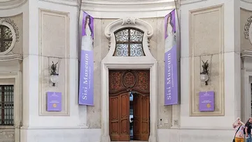 Museum entrance with wooden doors and banners.