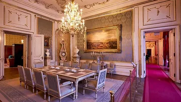 Elegant dining room with chandelier and artwork.