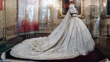 Elegant white wedding dress displayed in museum.