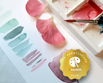 Watercolor palette with paint samples and petals.