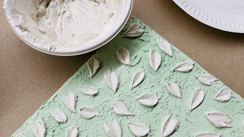 Textured plaster leaves on green canvas.