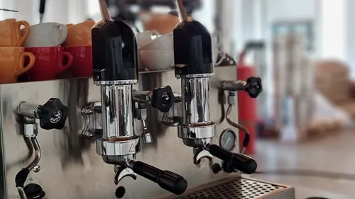 Espresso machine with coffee cups nearby.