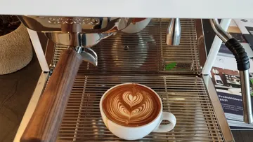 Coffee machine with latte art cup beneath.