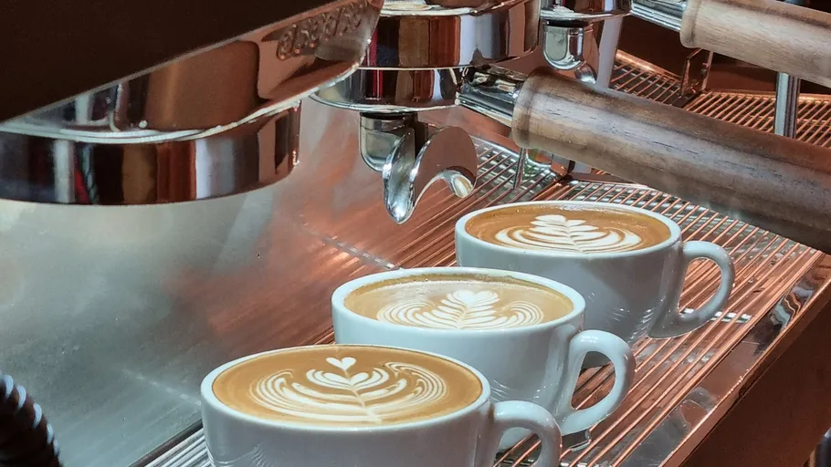 Espresso machine making coffee with latte art.