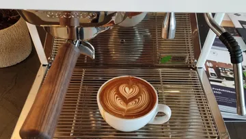 Espresso machine with a cup of latte art.