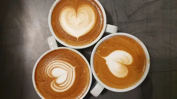 Three cappuccinos with heart latte art.