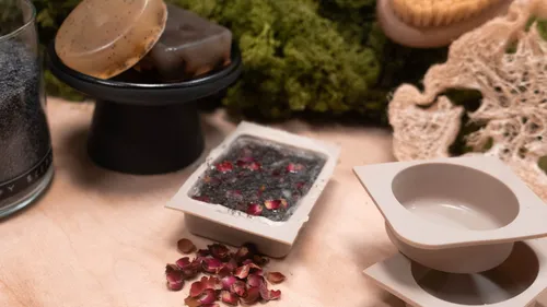 Handmade soaps and molds on wooden table.