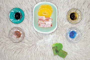 Colorful drinks and snacks on fuzzy surface.